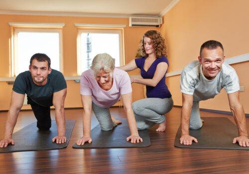 Gruppe macht Rehasport im Fitnesscenter mit Fitnesstrainerin